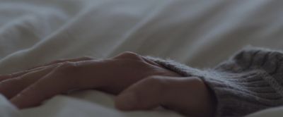 a close up of a person's hand on a bed