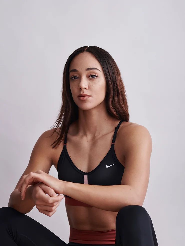 a woman sitting on the ground in a sports bra top