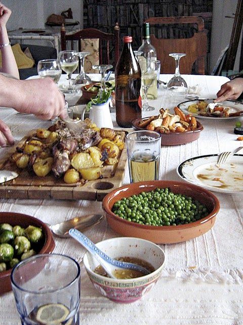 a group of people sitting at a table with plates of food