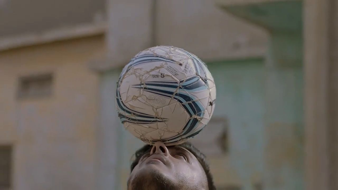 a man is balancing a soccer ball on his head