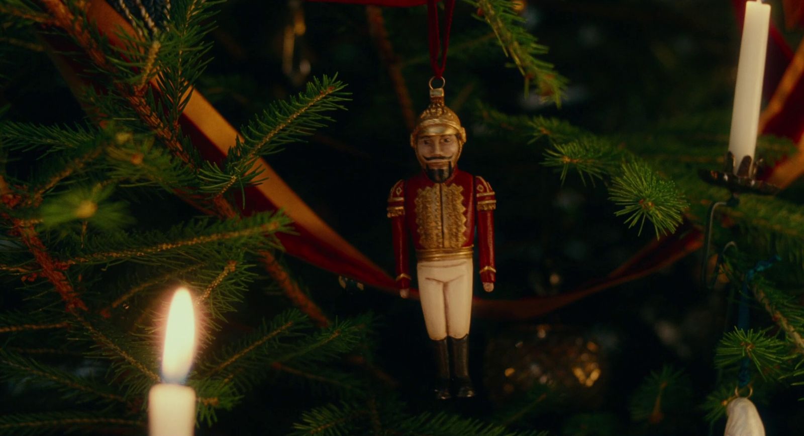 a nutcracker ornament hanging from a christmas tree