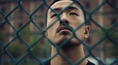 a man looking up through a chain link fence