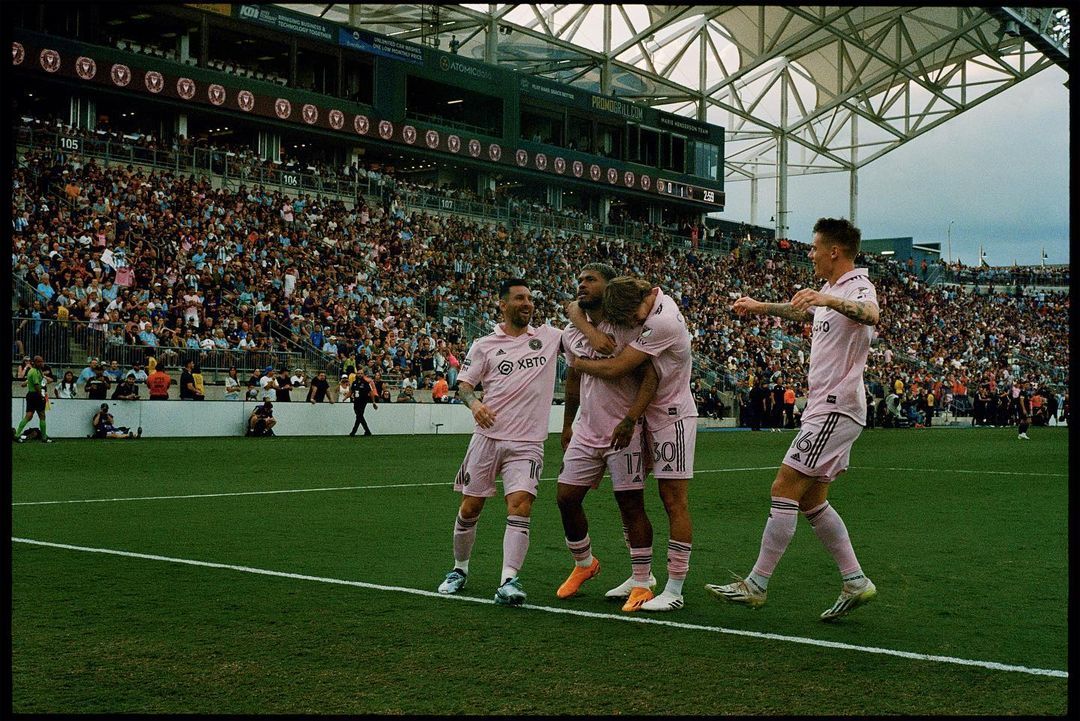 a group of men standing on top of a soccer field