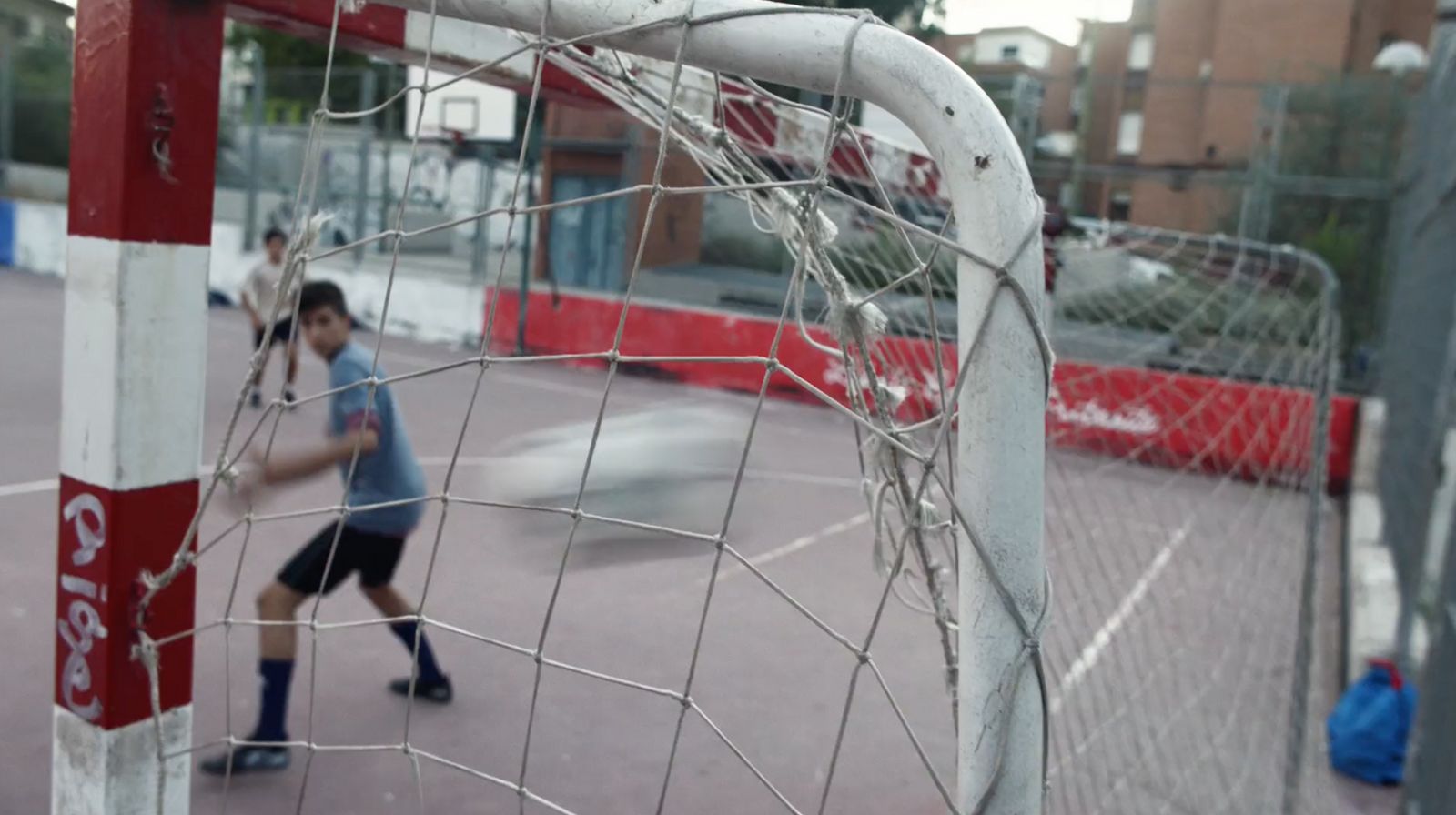 a young boy playing a game of tennis on a court