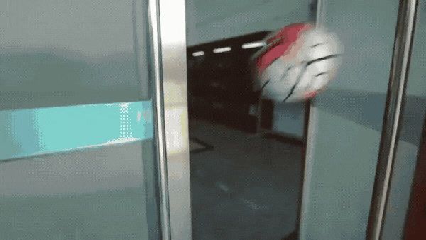 a red and white ball sitting on top of a glass door