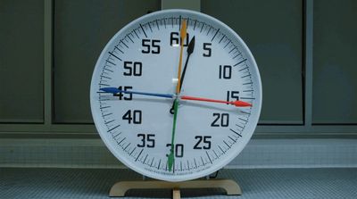 a white clock sitting on top of a wooden stand