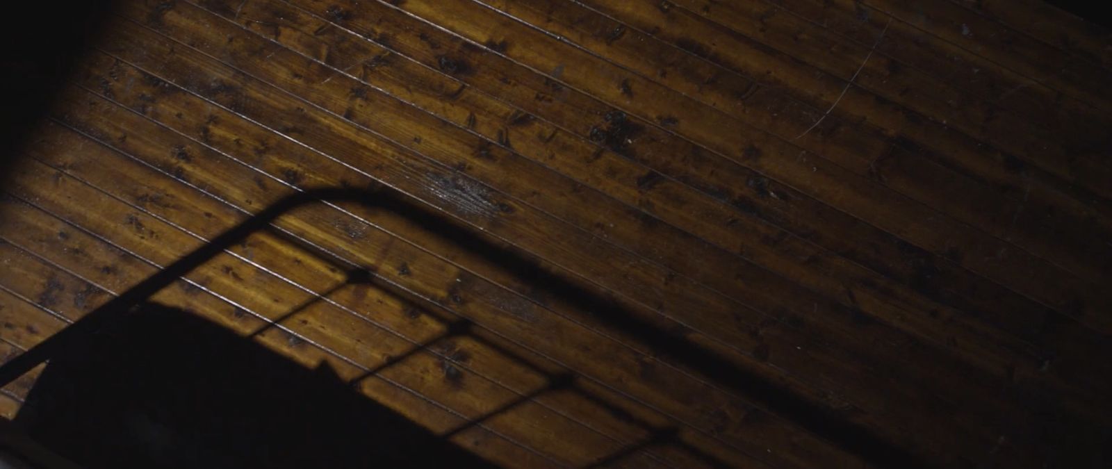 a wooden floor with a metal hand rail