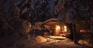 a cabin is lit up at night in the snow