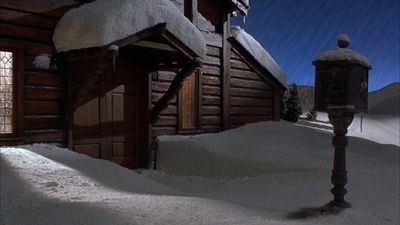 a house covered in snow next to a street light