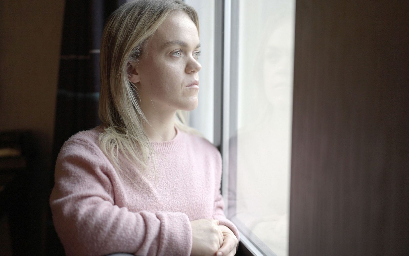 a woman looking out of a window at something