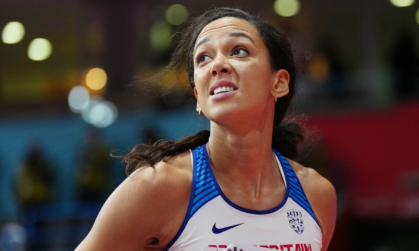 a woman in a blue and white shirt is playing basketball