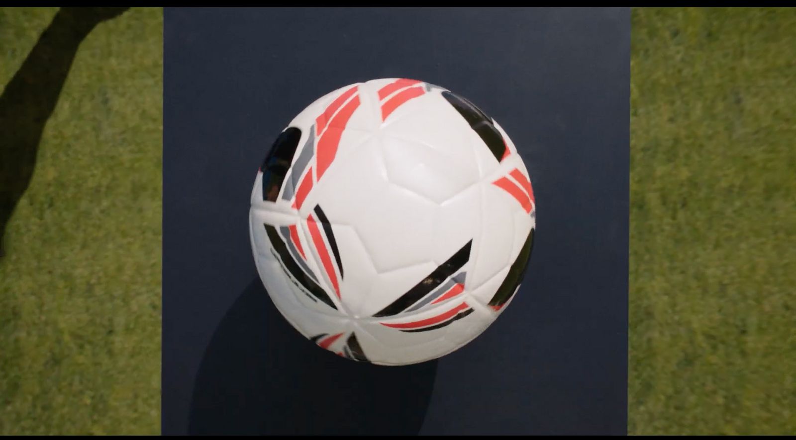 a white soccer ball with red and black stripes