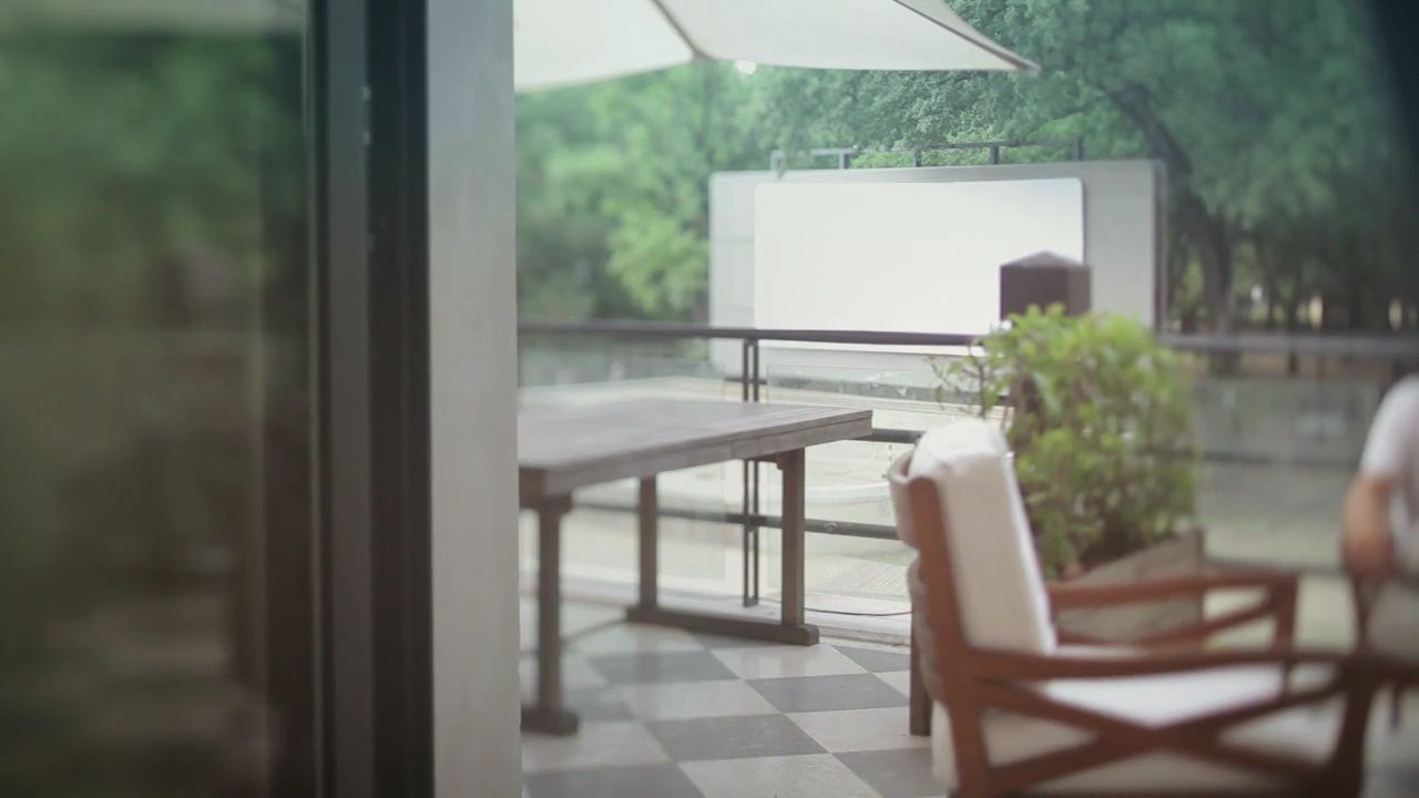 a patio with a table, chairs, and a projection screen