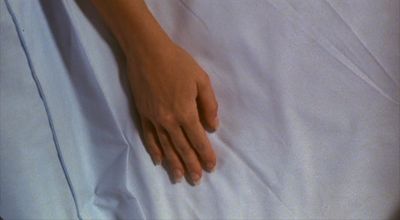 a person's hand resting on a white sheet