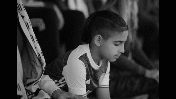 a young girl sitting on the ground looking at her cell phone