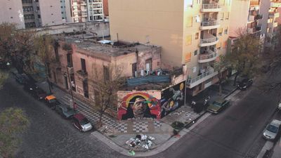 an aerial view of a city street with cars parked on the side of the street