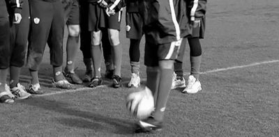 a group of young people standing around a soccer ball