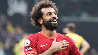 a man with curly hair and a beard wearing a red shirt