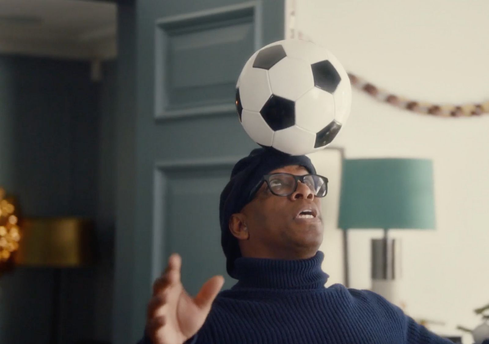 a man balancing a soccer ball on his head