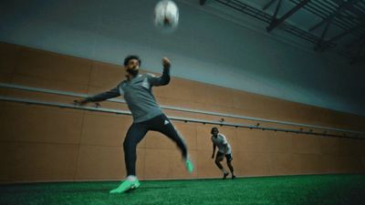 two men are playing with a soccer ball