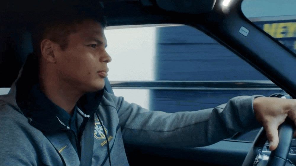 a man driving a car in a parking lot