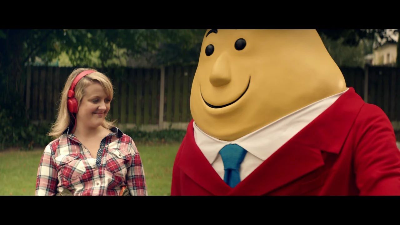 a young girl standing next to a giant teddy bear