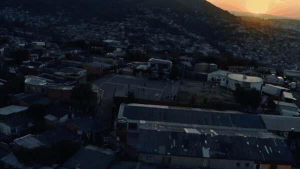 an aerial view of a city with mountains in the background