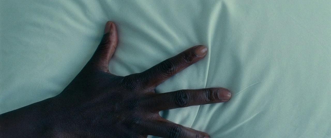 a person's hand on top of a white sheet