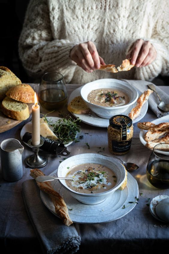 a person sitting at a table with a bowl of soup