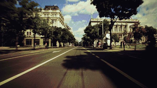 a car driving down a street next to tall buildings