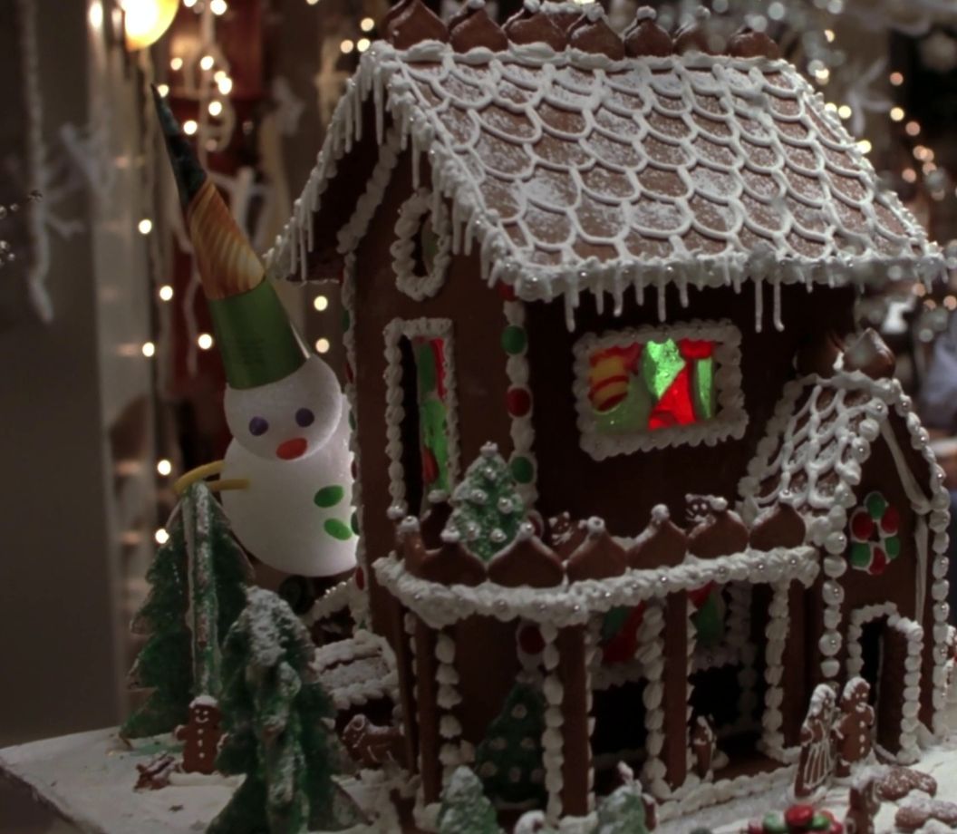 a gingerbread house with a snowman on top of it