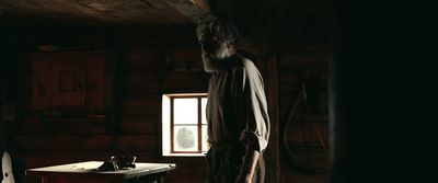 a man standing in a dark room next to a desk