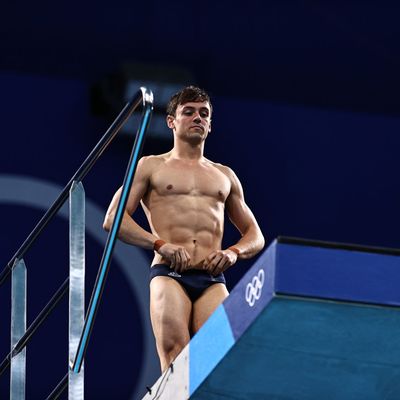 a man without a shirt standing on a diving platform