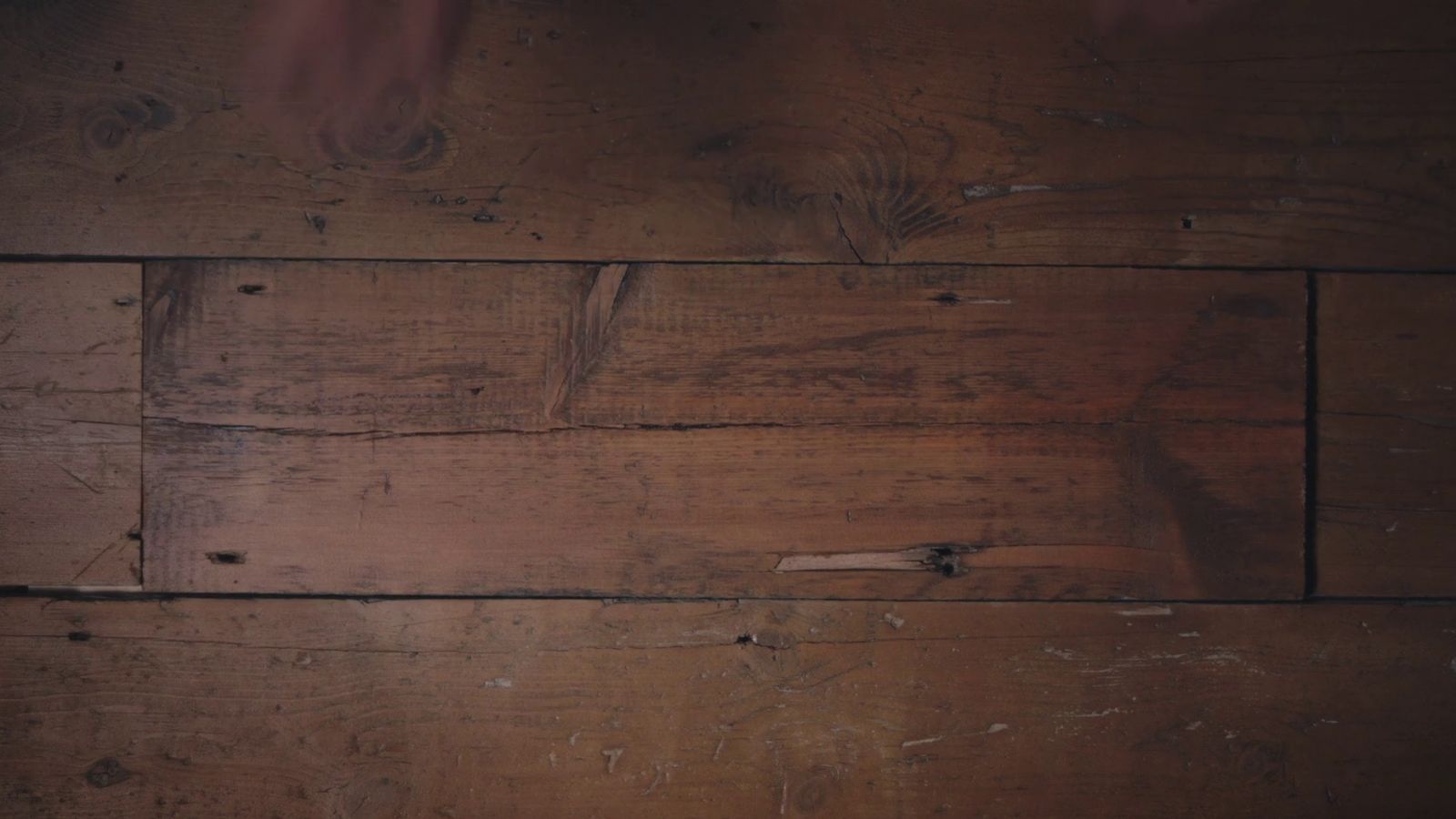 a close up of a wooden floor with peeling paint