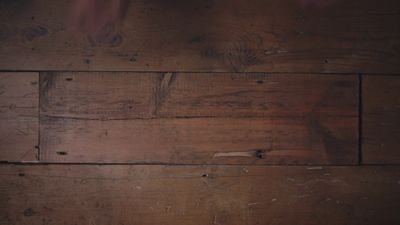 a close up of a wooden floor with peeling paint