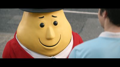 a man standing next to a large yellow character