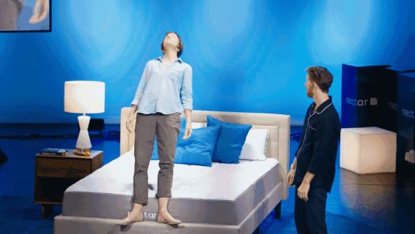 a woman standing on a bed in a room