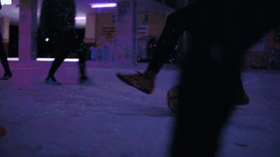 a group of people walking down a street at night