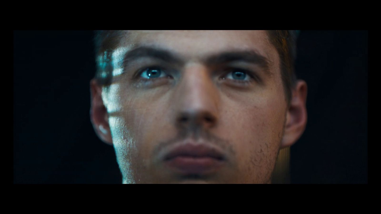 a close up of a man's face with blue eyes