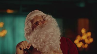 a man in a santa suit brushing his teeth