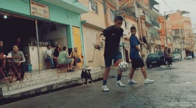 a man and a woman walking a dog down a street