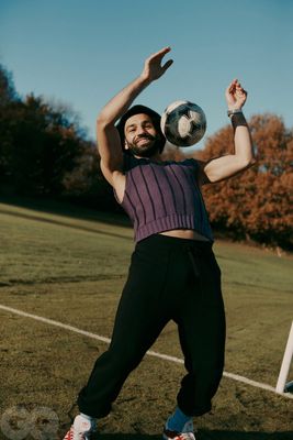 a man holding a soccer ball on top of a field