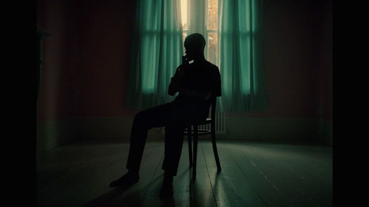 a man sitting in a chair in front of a window