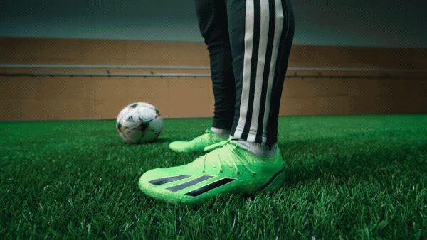 a person standing next to a soccer ball on a field