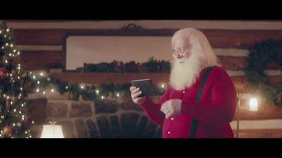 a man dressed as santa claus using a tablet