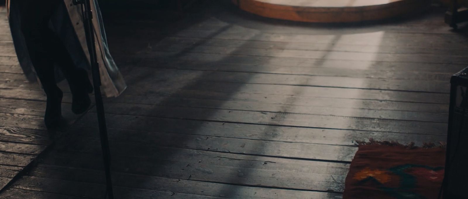 a person standing on a wooden floor with a suitcase