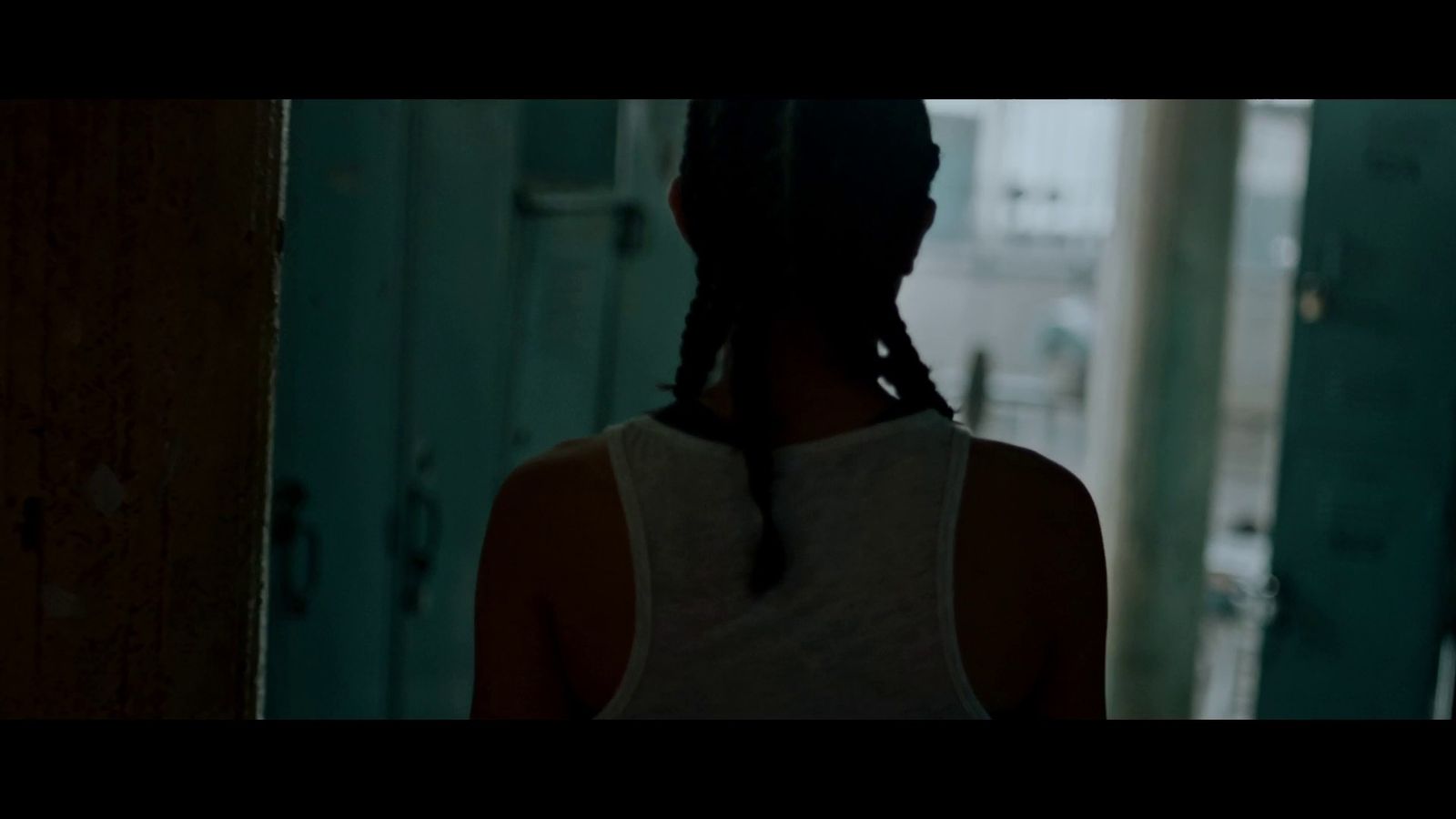 a woman with braids standing in a hallway