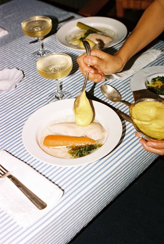 a table with a plate of food and a glass of wine