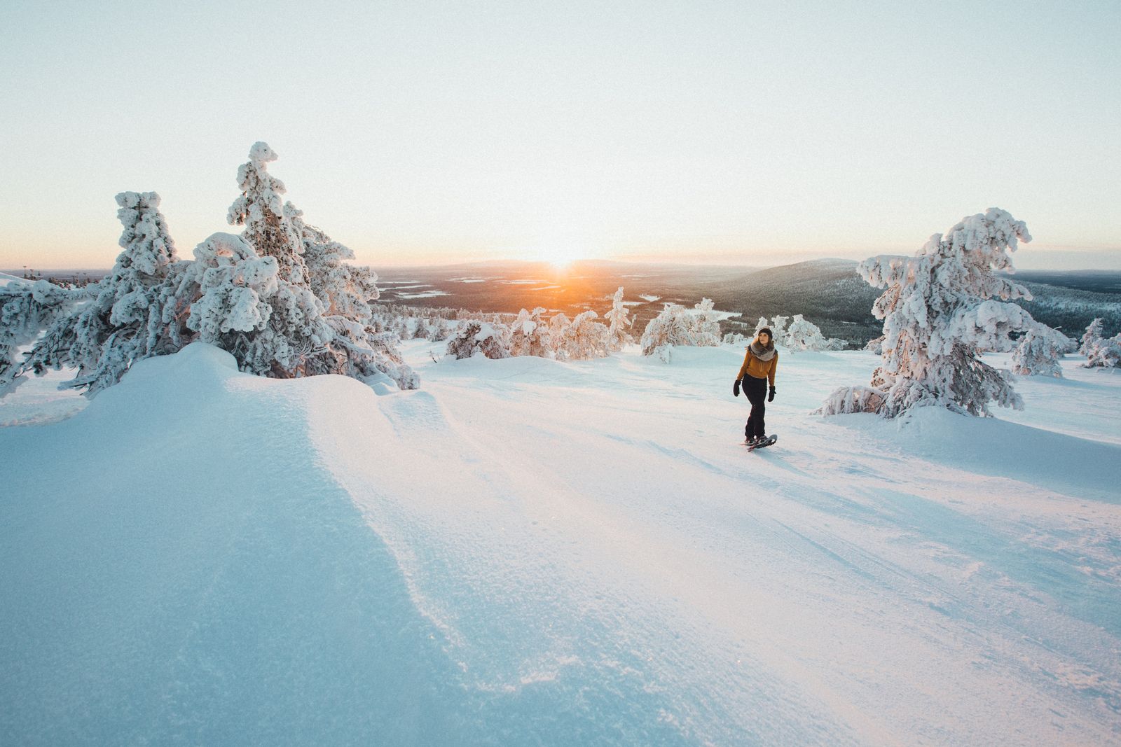 a person riding a snowboard down a snow covered slope