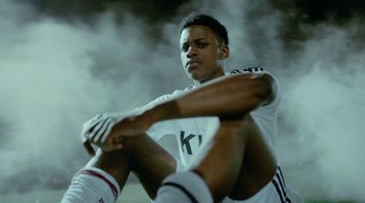 a soccer player sitting on the ground in the smoke